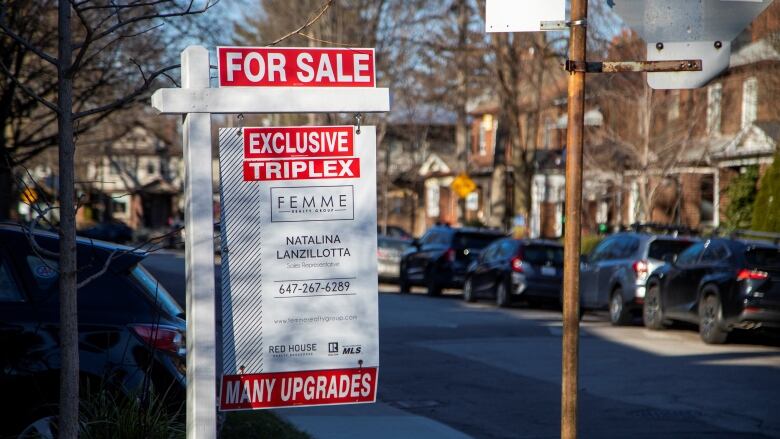 A sign advertises a triplex home for sale in Toronto, in December 2021.