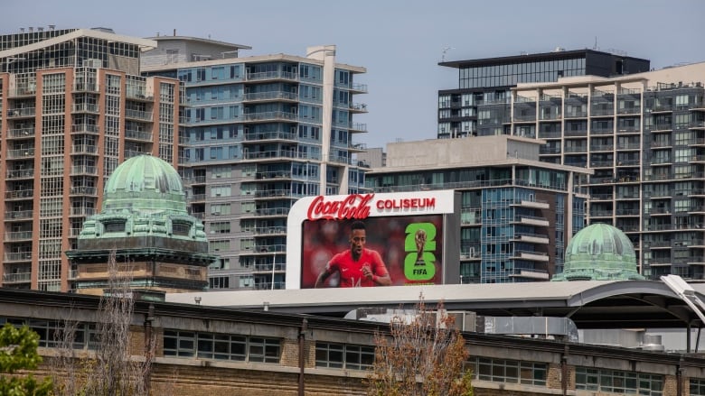 A billboard showing FIFA's 2026 campaign amid condos and high-rises.