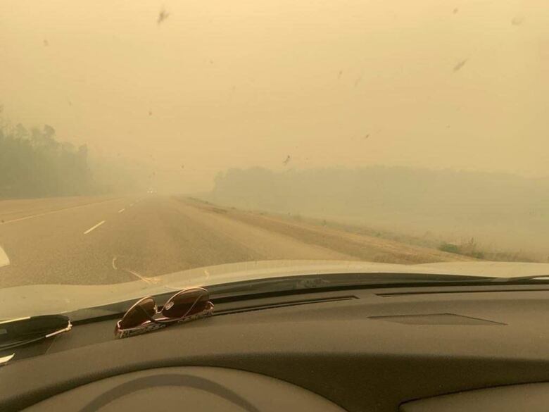 Smoky sky on a highway as pictured from a car.