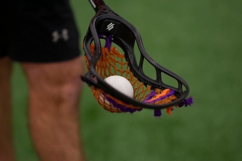 Closeup of a ball in a lacrosse scoop.