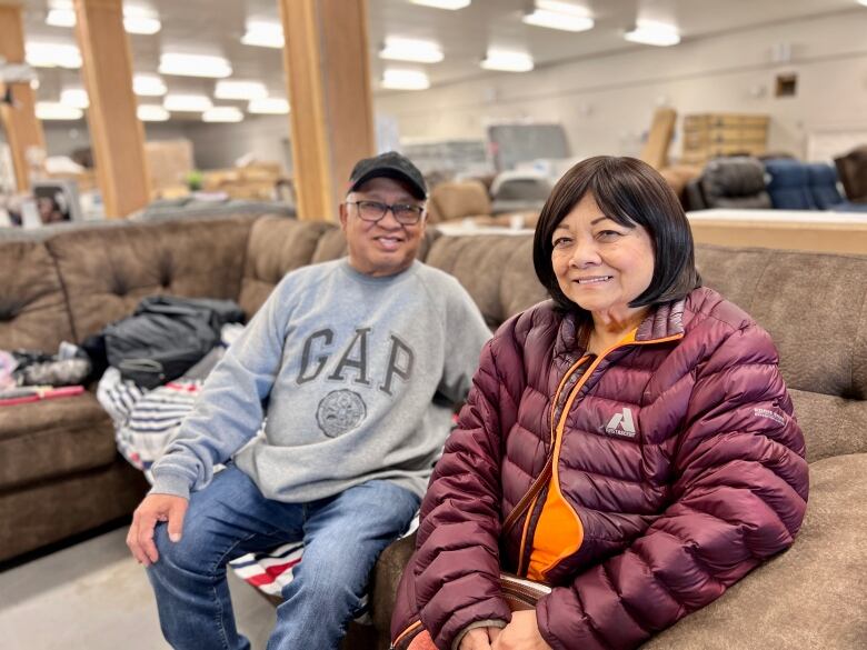 Smiling couple on couches.