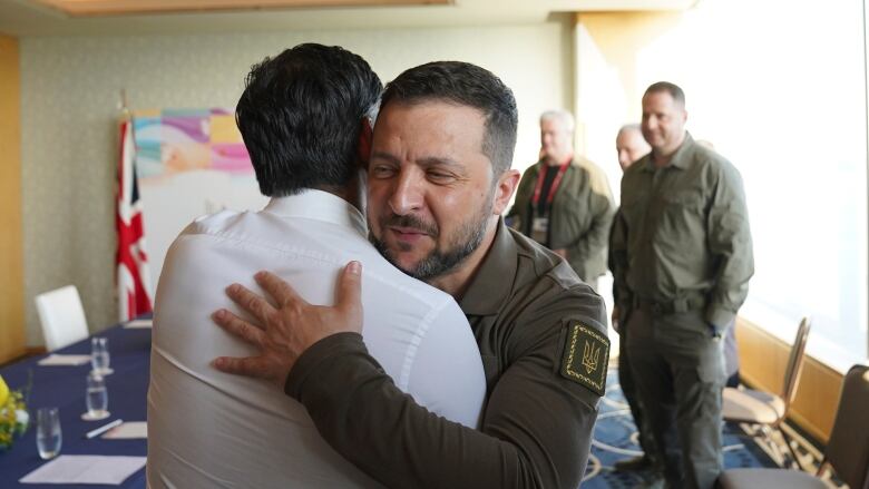 Two men hug upon greeting.