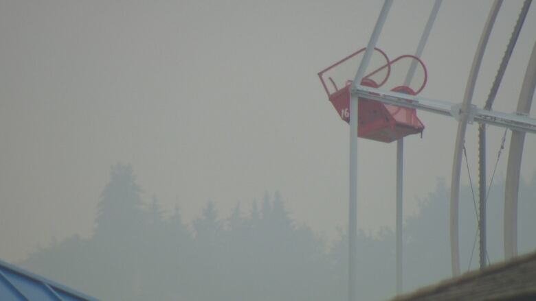 A ferris wheel car surrounded by smokey conditions.