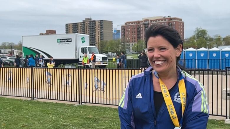 Amber is smiling with a medal around her neck. 