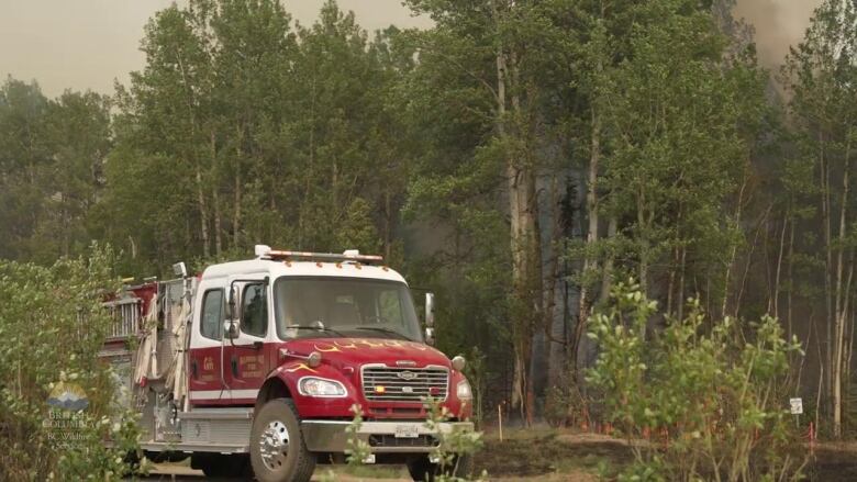 A fire truck in the woods.