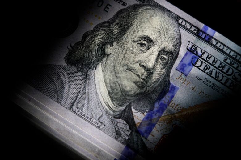 Extreme close-up on a U.S. 100 dollar bill, showing face of Benjamin Franklin