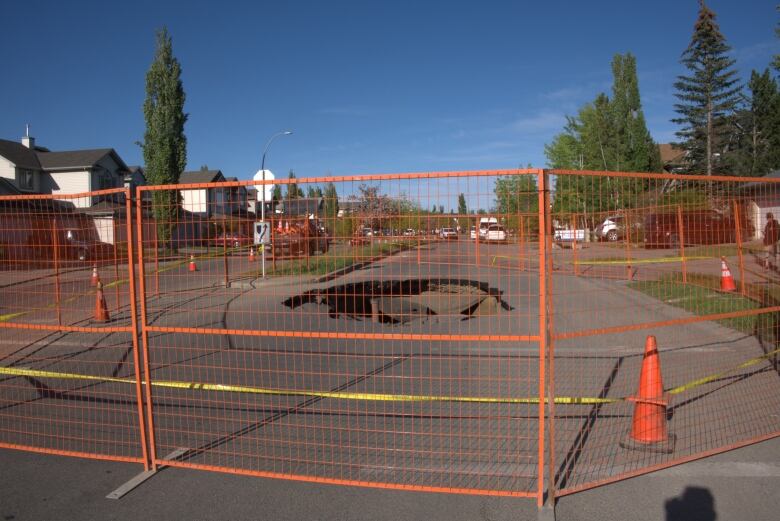 A fence around a large sinkhole.