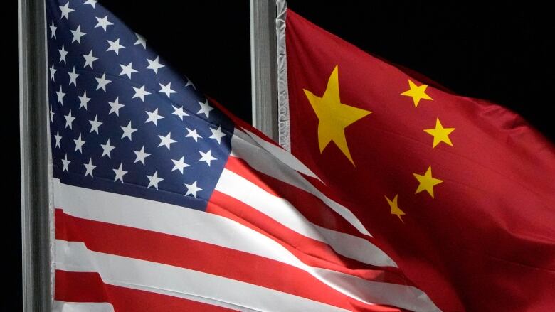 The American and Chinese flags wave side by side.