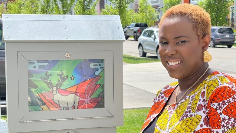 Toyin Oladele stands next to one of 13 display boxes on display around the city.