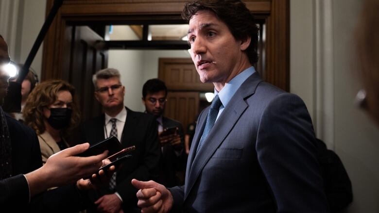 justin trudeau surrounded by reporters