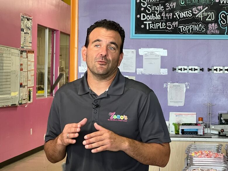 A person stands inside an ice cream shop.