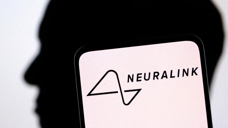 A photo illustration of Elon Musk's silhouette is shown behind the Neuralink logo.