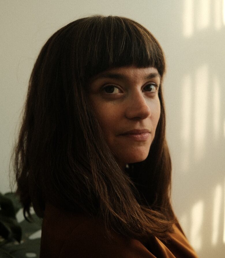 A close up portrait of a woman with long dark hair.