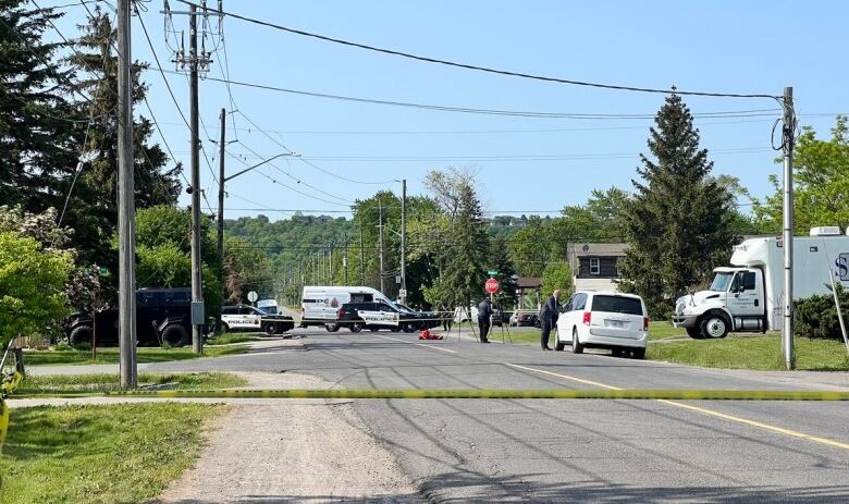 Police and SIU vehicles can be seen on a road blocked off. 