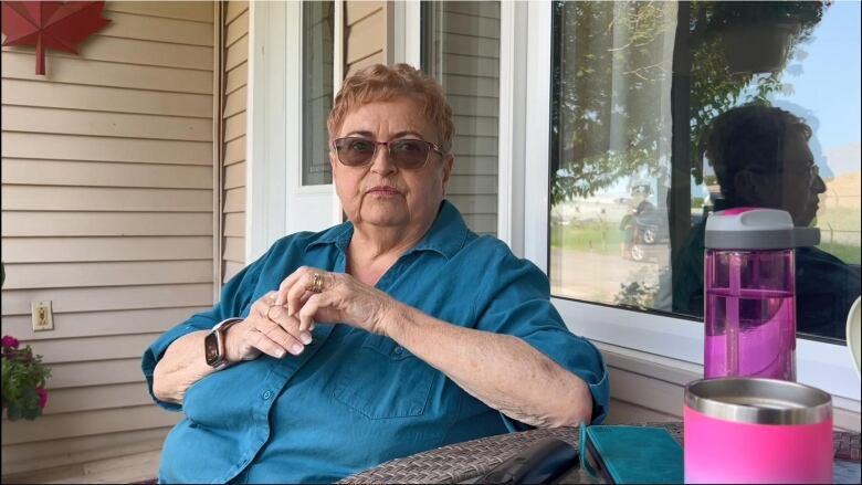 A woman sitting on a front porch.