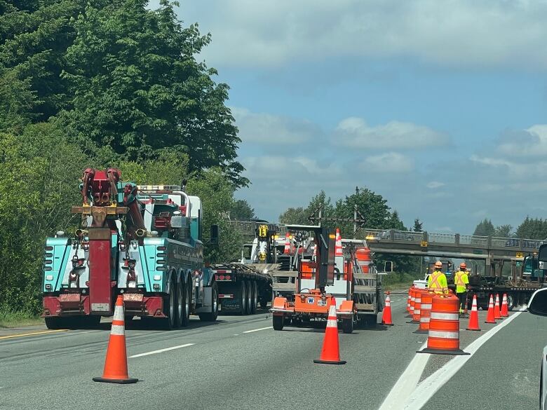 trucks, pylons and people in high visibility gear on the road