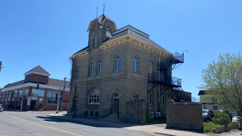 An outdoor exterior shot of a two-story historical building made of stone.