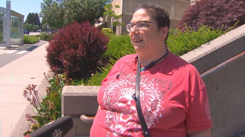 A woman in a pink T-shirt expresses her concerns about housing in Surrey.