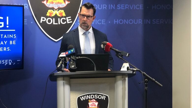 A man stands at a Windsor police podium.