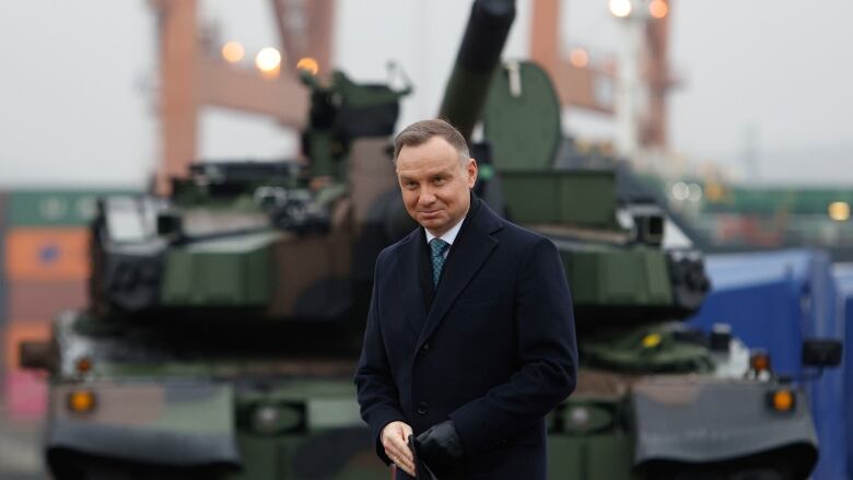 Polish president stands in front of a tank.