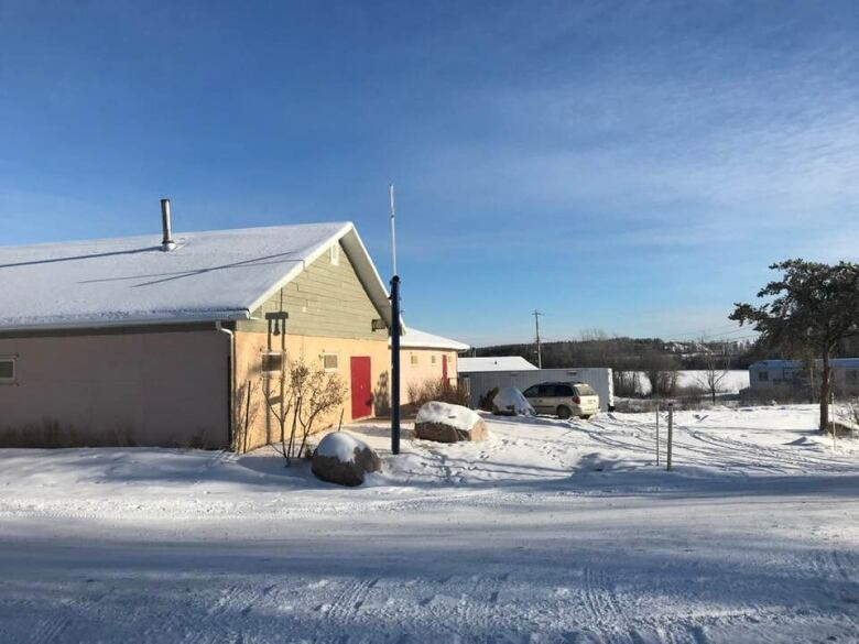 A yellowish and green church building is pictured on a snowy day.