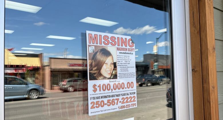 A poster featuring a smiling woman has the words Missing in red on top of the photo and $100,000 below it.