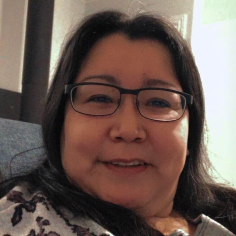 A headshot of a smiling Inuk woman wearing glasses.