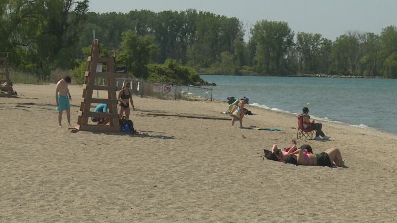 Beachgoers set up and relax at Sandpoint Beach in Windsor. The city says it officially opens with staffed lifeguards June 10, weather and water quality permitting.