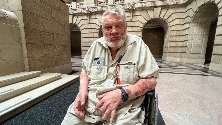 A man in a wheelchair sits in the rotunda of the Manitoba Legislature.