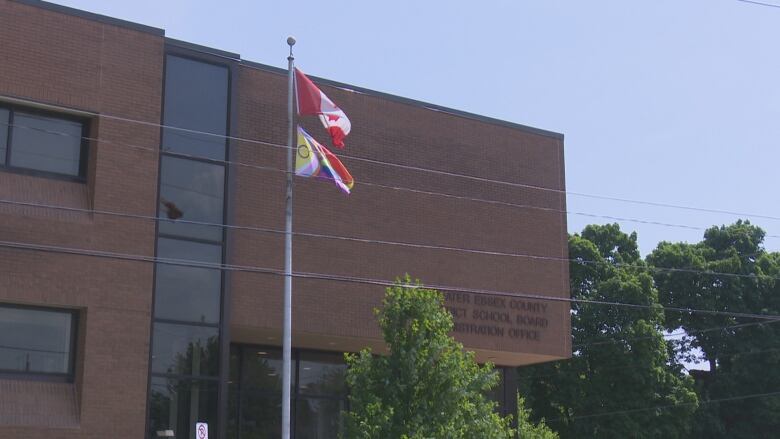 The Canadian and Pride Month flags fly in front of the offices of the Greater Essex County District School Board Friday.