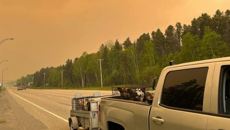 picture of a truck on the road with heavy smoke in the sky