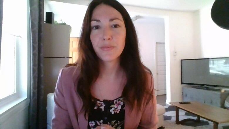 A woman sits in front of a computer.