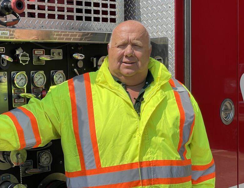 Peter Saunders pictured next to a fire truck, wearing a yellow reflective vest