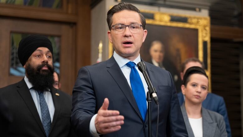 Conservative Leader Pierre Poilievre speaks into a microphone