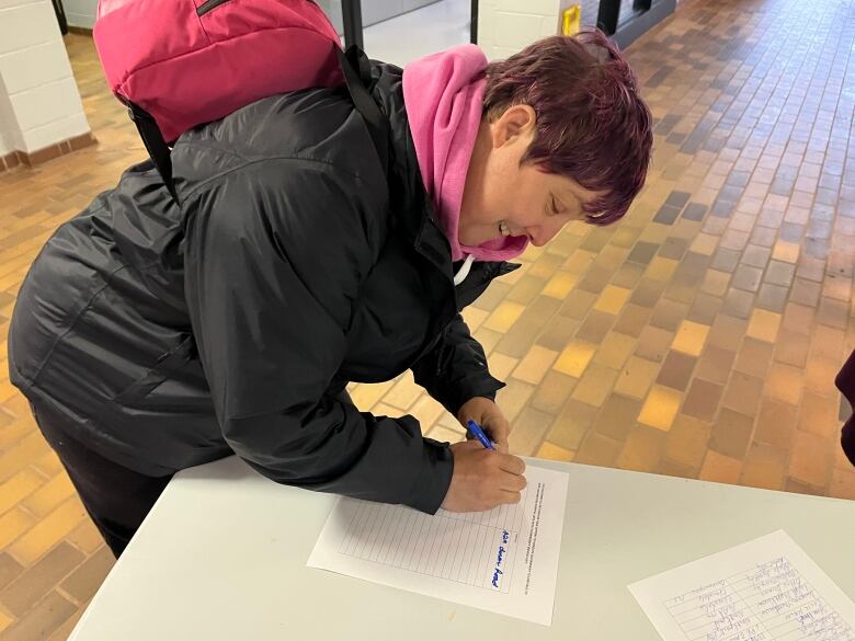 A woman signs a petition