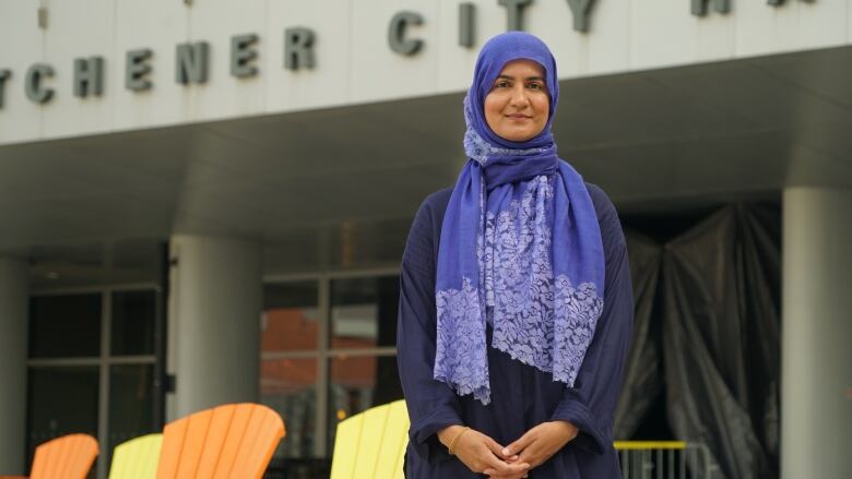 A woman standing in front of a city hall building.