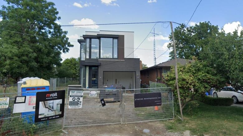 A home under construction behind a fence.