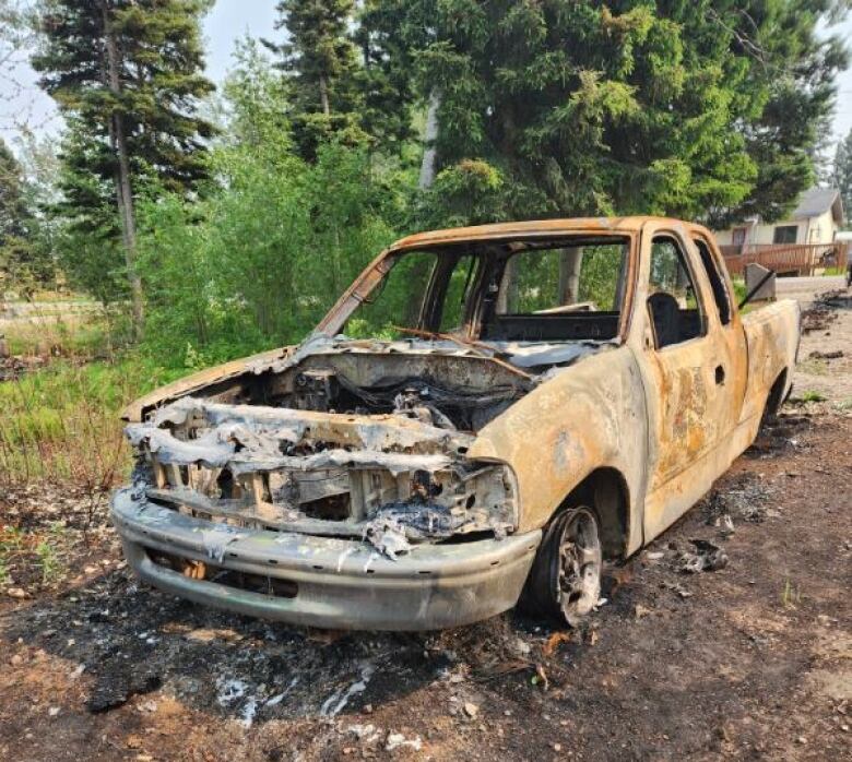 Burned out truck on dirt.