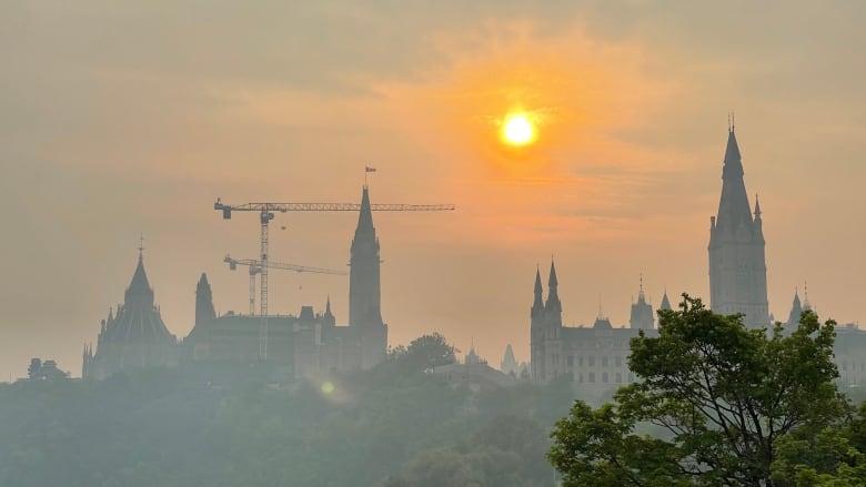 A smoky, hazy sunrise over a legislature.