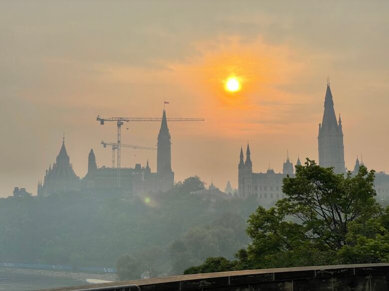 A smoky, hazy sunrise over a legislature.