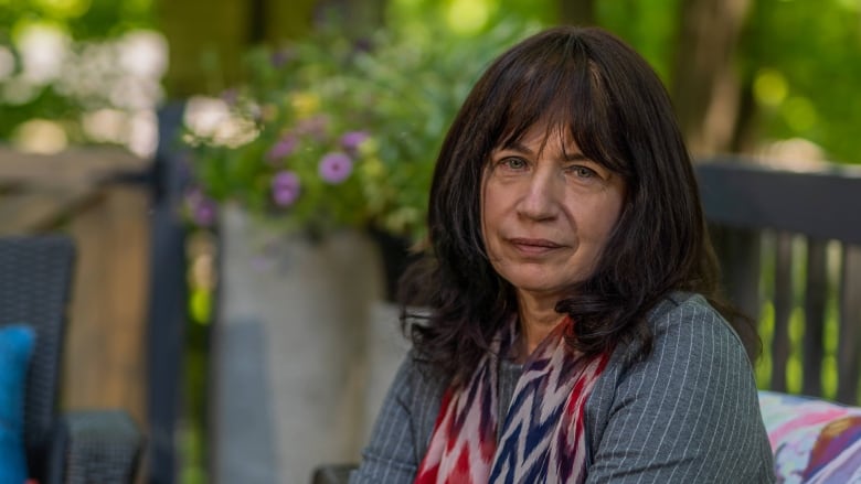 woman looking at camera while sitting in backyard