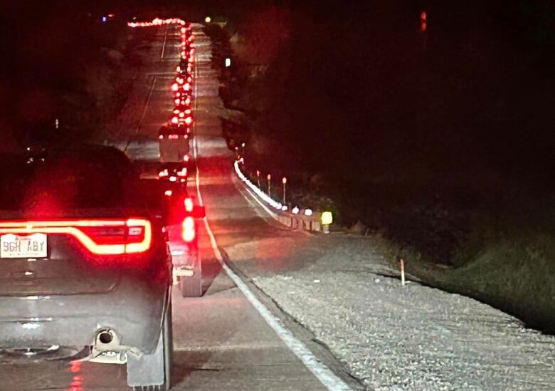 A nightime shot of a long line of cars leaving Chibougaumau and Ouj Bougoumou area. 