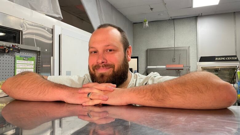 Erik Tamm crosses his arms across the counter of his meat stall at the Oshawa Market.