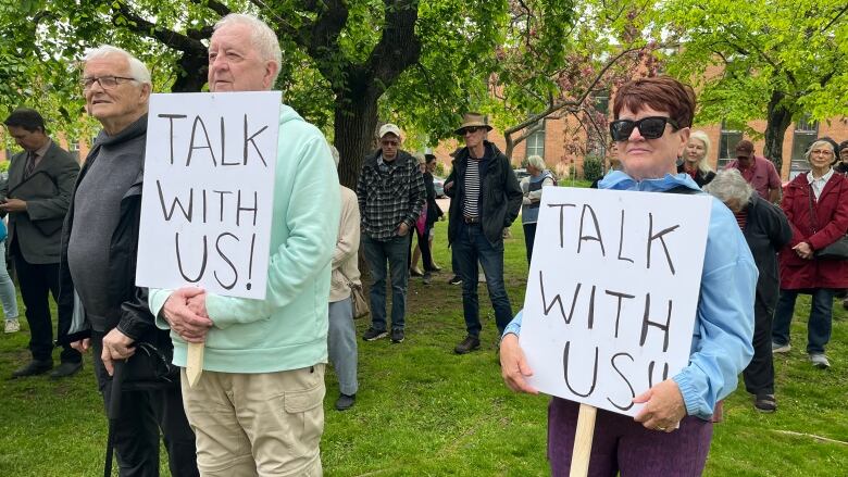 Two protestors stand on grass holding 