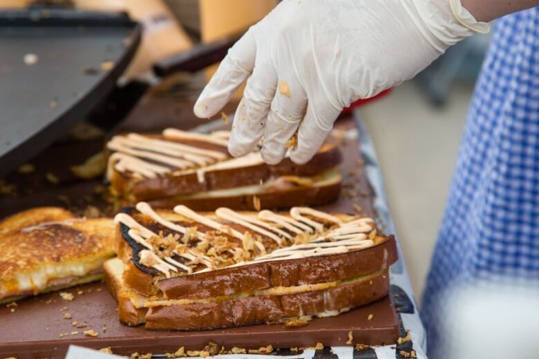 A grilled cheese with flakes and sauce on top.