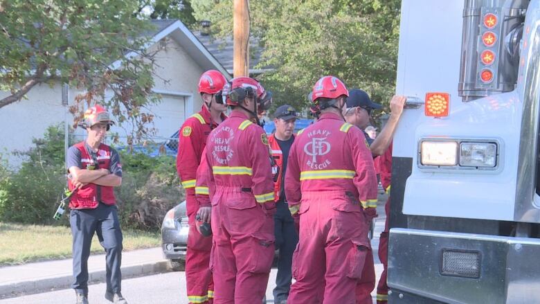 Calgary fire department heavy rescue crews gather near a white truck. 