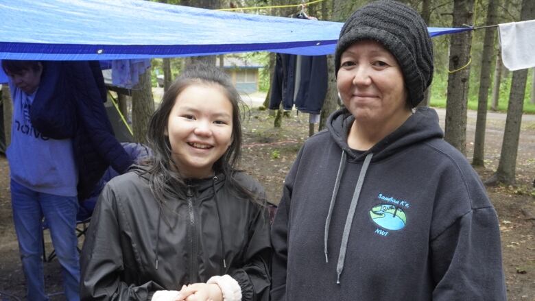 Girl and woman stand at campground.