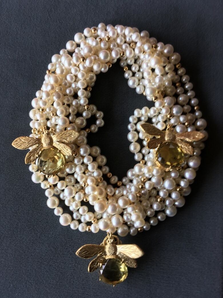 Choker of at least ten strands of perfectly spherical pearls punctuated by large gold and gemstone honey bees.