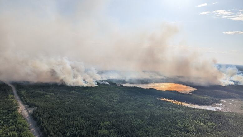 Smoke rises above a lake.