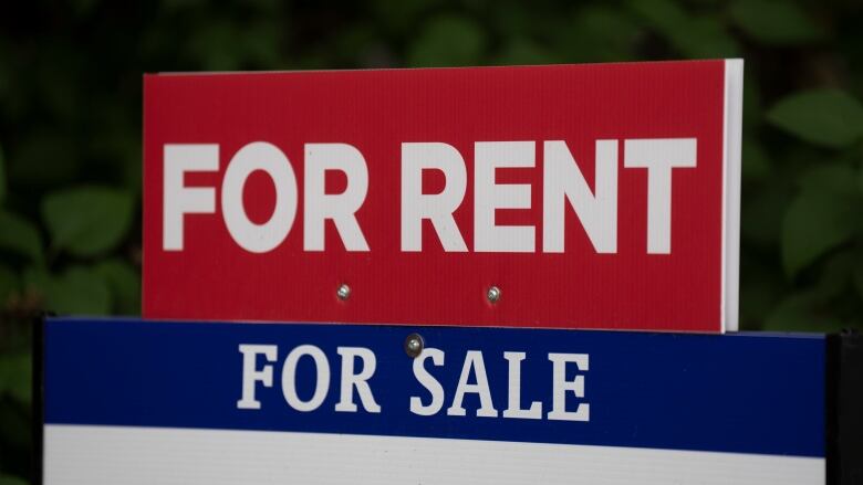 A red for rent sign on top of a blue for sale sign.